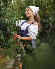 Beautiful happy young girl with peach garden in summer