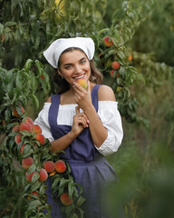 Beautiful happy young girl with peach garden in summer