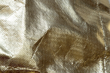 Gold glitter background with oilcloth texture, abstract material with gloss and folds for...
