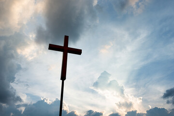 A christian cross under cloudy sky