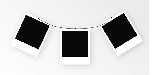 Three blank polaroid photos suspended on a string, arranged against a wall, evoke memories and anticipation