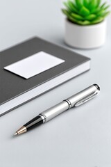 Silver Pen and Grey Notebook Flatlay on Light Grey Desk