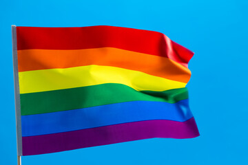 Rainbow flag waving on blue background