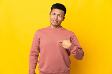 Young Ecuadorian man isolated on yellow background with surprise facial expression