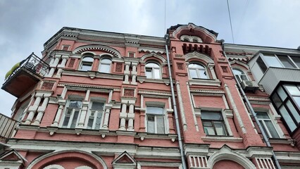 Kyiv, Ukraine, 06.26.2025, beautiful old pink house with Ukrainian flag on balcony