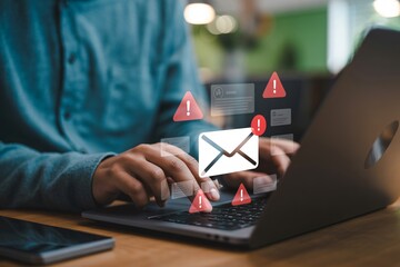 Person using a laptop with a spam alert concept showcasing email phishing, virus warnings, and computer security issues.