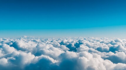 Naklejka premium Dense layer of white clouds stretches to the horizon under a bright blue sky aerial view