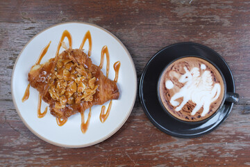 caramel  almond croissant with mocha on the table