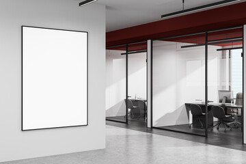 Empty poster frame on white office wall near glass conference room interior with modern furniture...