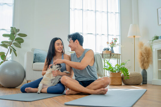 Asian family stay at home together with dog on holiday. Love couple lifestyle. Yoga and exercise concept.