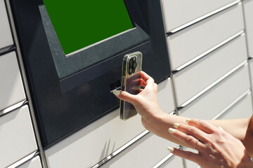 Woman uses smartphone to open locker. Contactless parcel pickup with mobile phone. Smart delivery technology. Outdoor self-service locker station. Modern convenience. Touchless digital access.