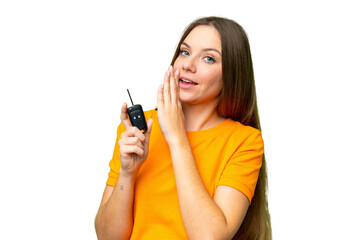 Young woman holding car keys over isolated chroma key background whispering something