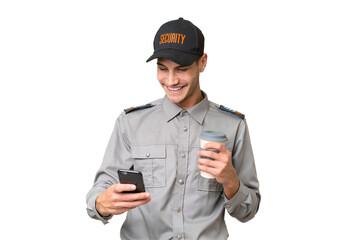 Young security man over isolated background holding coffee to take away and a mobile