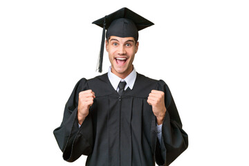 Young university graduate caucasian man over isolated background celebrating a victory in winner...