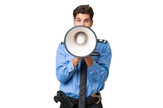 Young police man over isolated background shouting through a megaphone