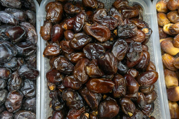 Date fruit on market stall fresh natural tropical healthy snack. Close up of ripe brown dates displayed on rustic market stall symbolizing abundance and natural harvest.