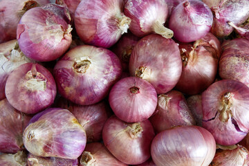 Red onion texture background. Food background of onion with concept of realistic, rough skin, dirty, bunch vegetable, herb, harvest, organic, healthy for display, backdrop, print, and web.
