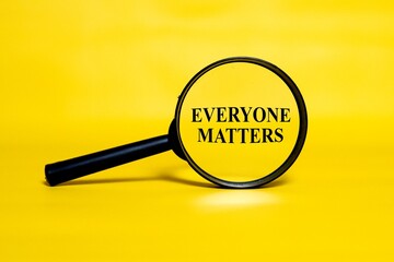 EVERYONE MATTERS concept zoomed through a magnifying glass isolated on a yellow background. 