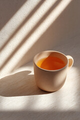 minimalist composition featuring handcrafted clay mug filled with tea placed on light wooden background