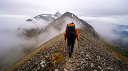 Fototapeta premium Mountain hiking adventure, steep rocky trail climb, mist-covered peaks, layered mountains in distance