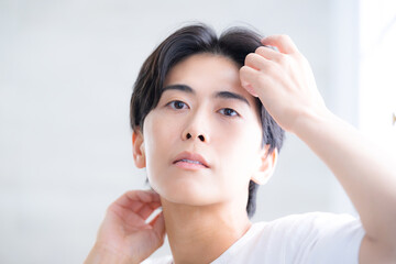 黒髪を触る透明感のある男性　クローズアップ...