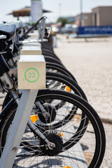 Public rental bicycles lined up at a docking station in Lisbon, Portugal. These eco-friendly bikes...