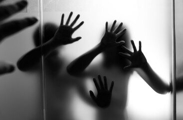 Silhouette of two people behind frosted glass