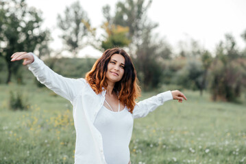 Obraz premium Portrait of a real happy woman without makeup who enjoys herself and life. Meditation in nature. 