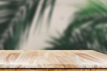 Empty wooden table with copy space and green plant leaves background