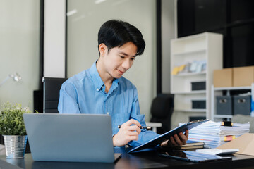 Business man working at office with laptop and documents on his desk, financial adviser analyzing data.