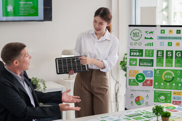 Business professionals discuss ESG strategies green business practices and carbon reduction...