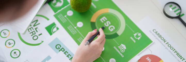 Adult Asian hand analyzing ESG environmental social governance report for carbon footprint reduction and green business future