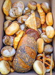 Artisan breads displayed in a wicker basket at a local bakery during a sunny afternoon