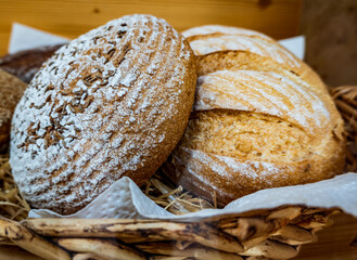 Artisan breads displayed in a wicker basket at a local bakery during a sunny afternoon