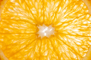 The photograph shows the surface details of a halved orange, studio light from behind.
