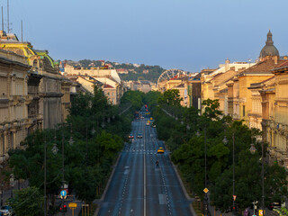 The famous Luxury shopping boulvard in Budapest. Name is Andrassy street. Lush trees both sides of road at Spring time