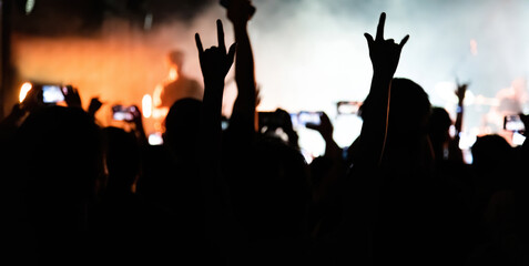 People hands making rock gesture at the concert