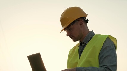 Power line inspector using laptop during transmission tower audit