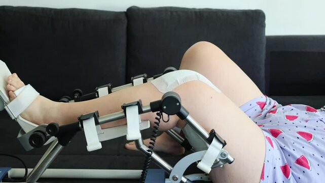 Physiotherapy at home: patient with knee orthosis and therapy device