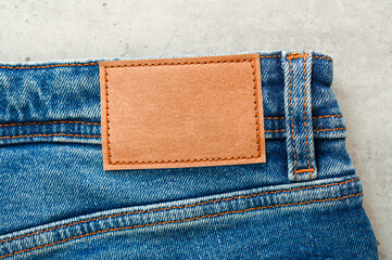 Top view of blue jeans with blank brown label, tag