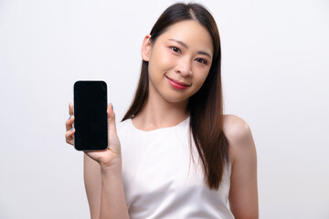 Fototapeta premium A beautiful Asian businesswoman shows a blank screen of mobile phone. She smiles at the camera