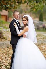 Fototapeta premium A bride and groom are posing for a picture in a forest