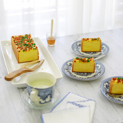 Some sweet cake served on fancy plate with a cup of tea