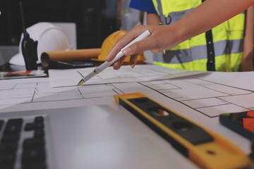 Closeup of team of industrial engineers meeting analyze machinery blueprints consult project on...