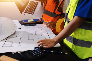 Closeup of team of industrial engineers meeting analyze machinery blueprints consult project on...