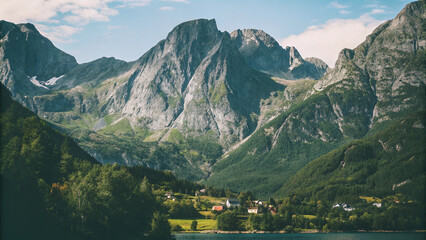 Majestic Mountains Tower Over a Lush Green Valley with a Serene Lake