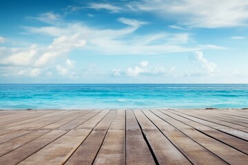 Fototapeta premium Empty wooden pier overlooking a beautiful turquoise ocean under blue cloudy sky