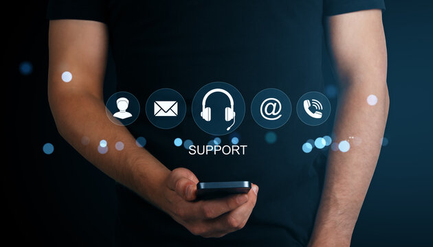 Man holding smartphone with glowing virtual icons representing online customer support options on dark background with blue light effects.