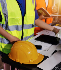 Closeup of team of industrial engineers meeting analyze machinery blueprints consult project on...