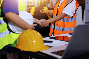 Closeup of team of industrial engineers meeting analyze machinery blueprints consult project on...